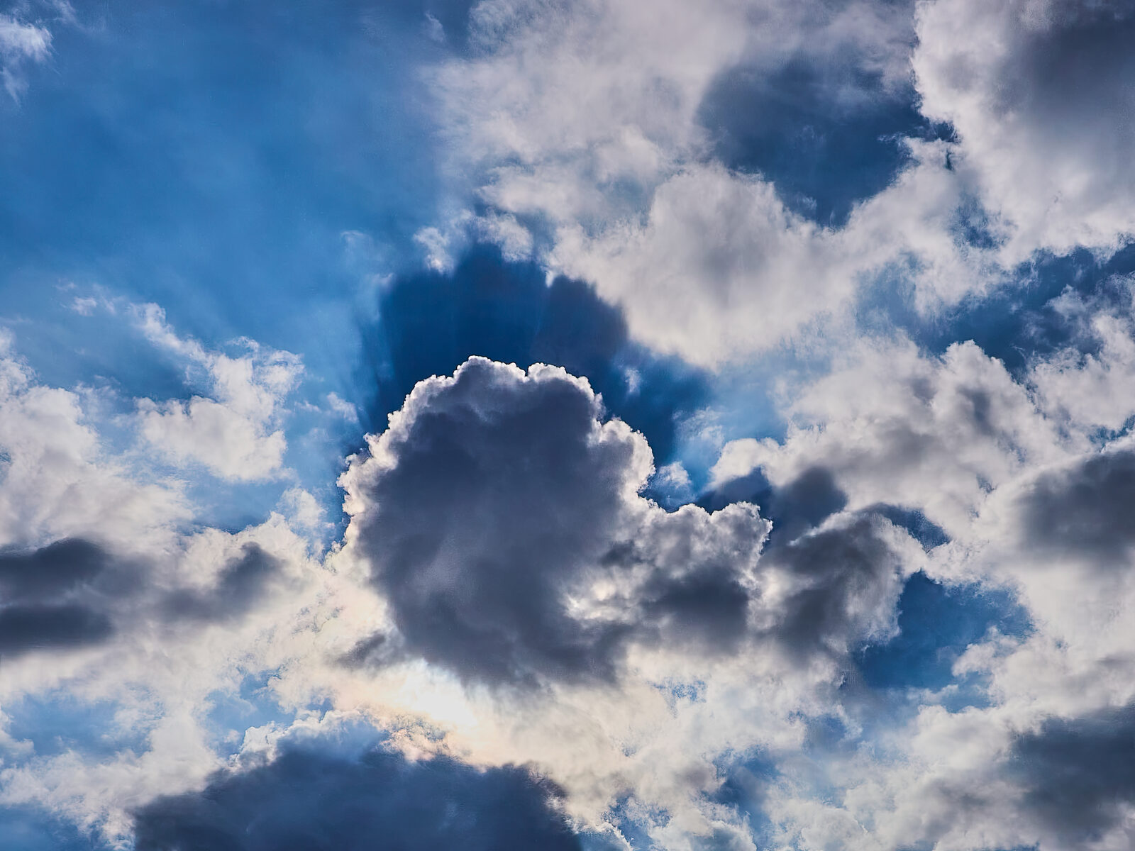 Sunlit cumulus clouds against a blue sky